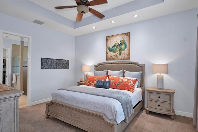 carpeted bedroom with ceiling fan, connected bathroom, and a tray ceiling