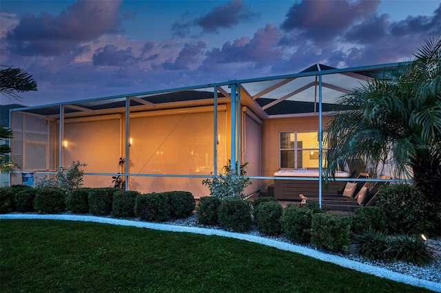 exterior space with a lanai and a lawn