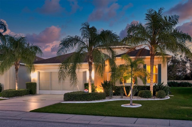 mediterranean / spanish-style home featuring a yard and a garage