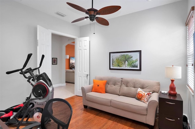 exercise area featuring light wood-type flooring and ceiling fan