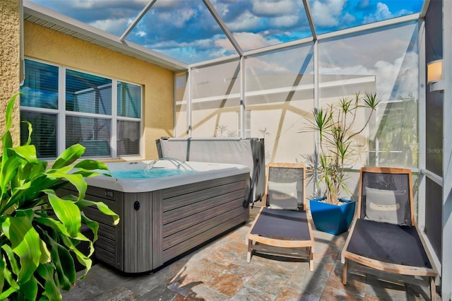 view of patio / terrace featuring a lanai and a hot tub