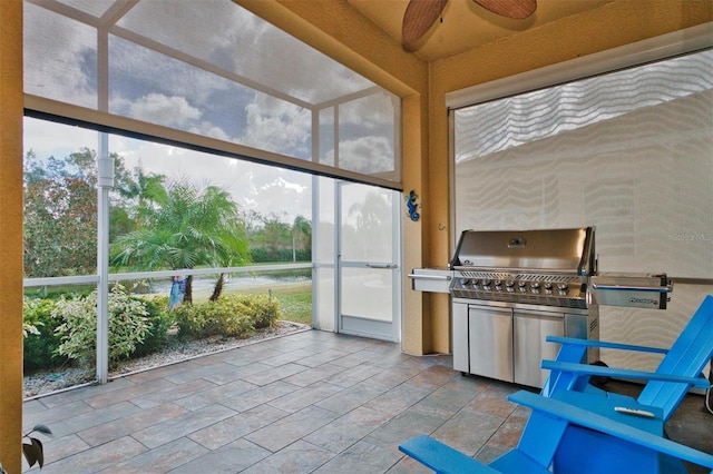 unfurnished sunroom featuring ceiling fan