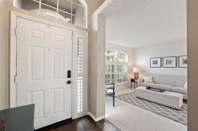 foyer with a textured ceiling and dark wood-type flooring