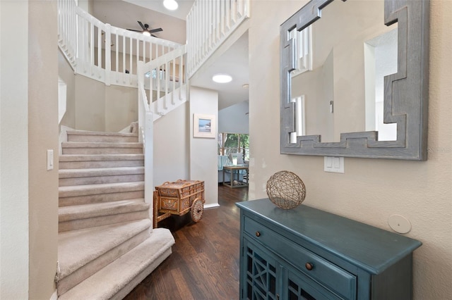 stairs featuring ceiling fan and hardwood / wood-style flooring