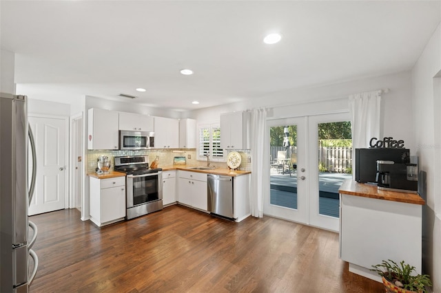 kitchen featuring dark hardwood / wood-style flooring, white cabinetry, appliances with stainless steel finishes, and french doors