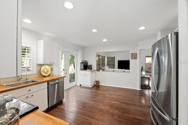 kitchen with sink, white cabinetry, stainless steel appliances, and dark wood-type flooring