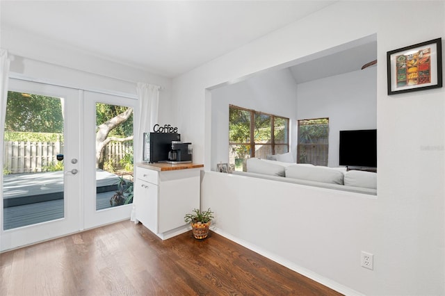 interior space with dark hardwood / wood-style floors, lofted ceiling, and french doors