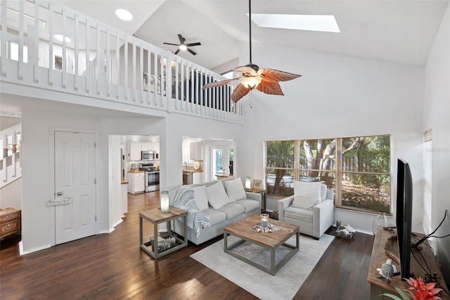 living room with a skylight, high vaulted ceiling, plenty of natural light, and dark hardwood / wood-style floors