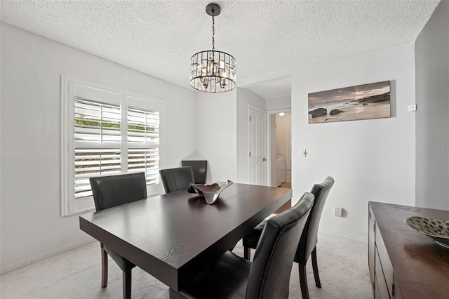 dining space with light carpet, a textured ceiling, and a notable chandelier