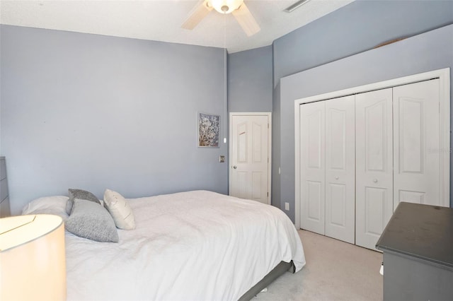 bedroom featuring ceiling fan, a closet, and light colored carpet