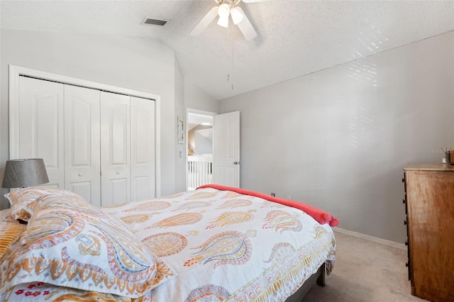 bedroom with ceiling fan, carpet floors, a textured ceiling, lofted ceiling, and a closet