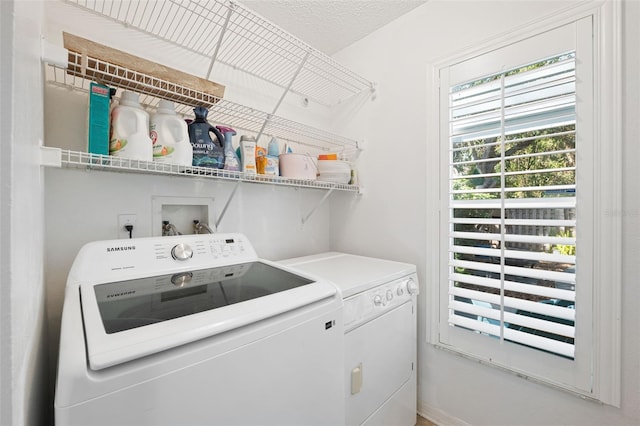 laundry room featuring independent washer and dryer and a textured ceiling