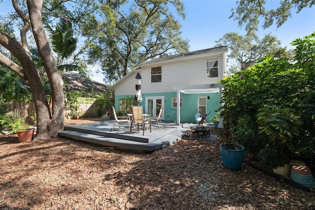 rear view of property featuring a wooden deck and french doors