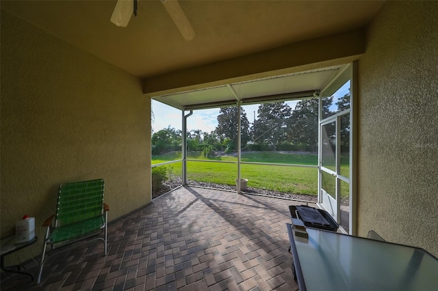 unfurnished sunroom featuring ceiling fan