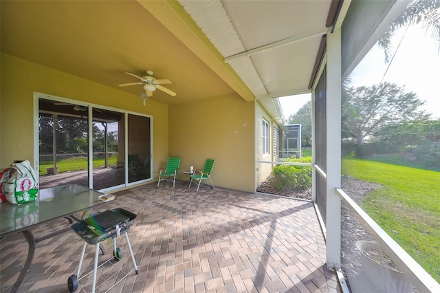 unfurnished sunroom featuring ceiling fan