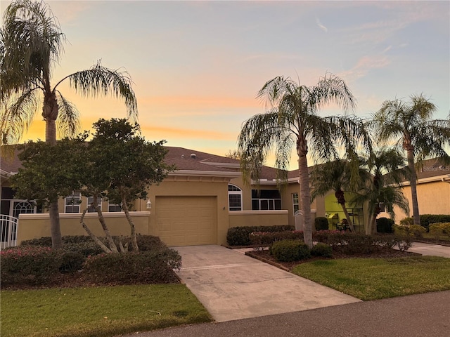 view of front of property featuring a garage and a lawn