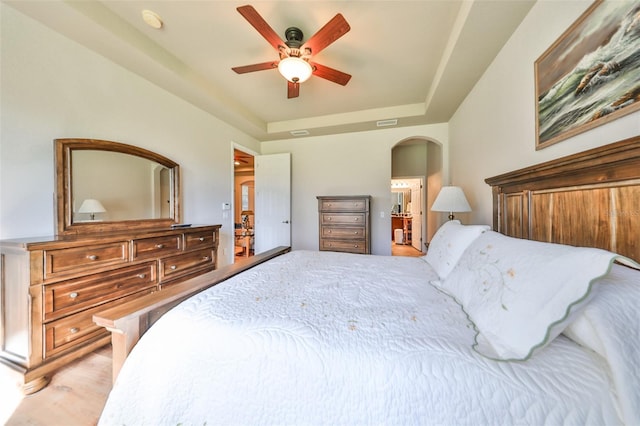 bedroom with a raised ceiling and ceiling fan