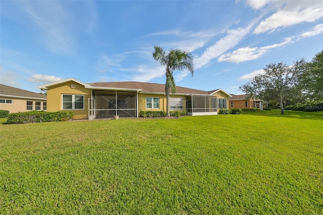 rear view of property featuring a sunroom and a lawn