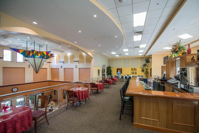 interior space with a drop ceiling and dark colored carpet