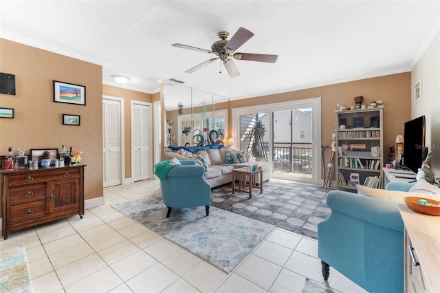 living room featuring light tile patterned flooring, ceiling fan, a textured ceiling, and ornamental molding