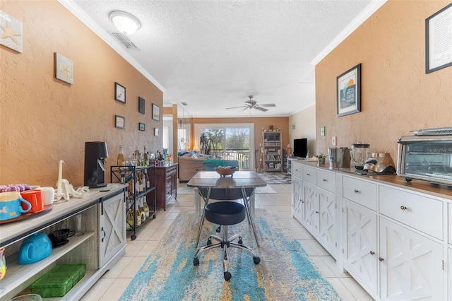 interior space featuring a textured ceiling, ceiling fan, crown molding, and light tile patterned floors