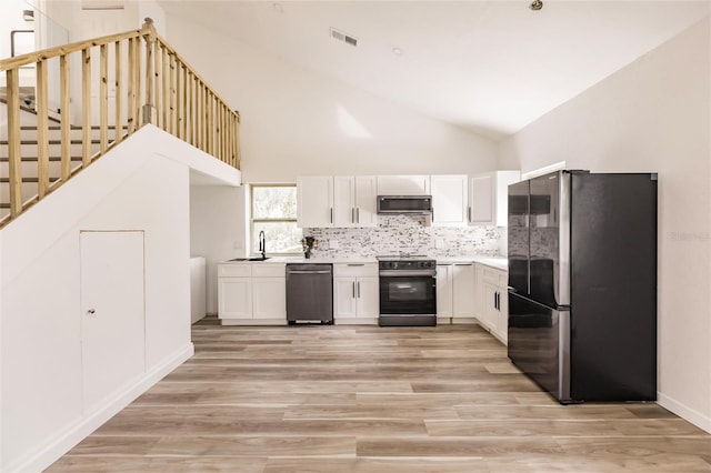 kitchen with light wood-type flooring, white cabinets, and stainless steel appliances