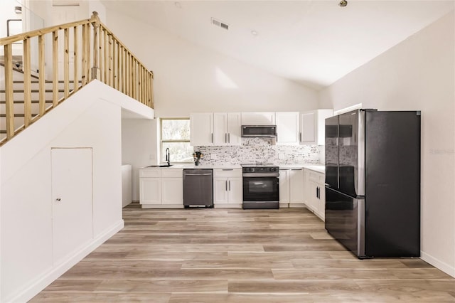 21048 Peachland Blvd, Port Charlotte, FL 33954 - kitchen with appliances with stainless steel finishes, a sink, white cabinets, light wood-style flooring, and high vaulted ceiling