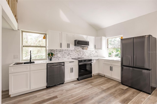 21048 Peachland Blvd, Port Charlotte, FL 33954 - kitchen with stainless steel appliances, a sink, light countertops, white cabinetry, and vaulted ceiling