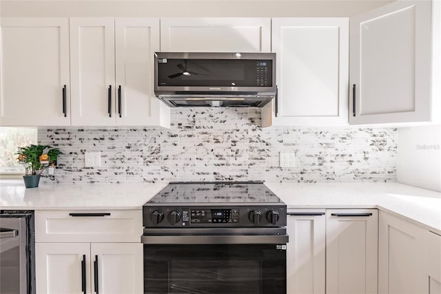 21048 Peachland Blvd, Port Charlotte, FL 33954 - kitchen with black range with electric cooktop, white cabinets, stainless steel microwave, and tasteful backsplash
