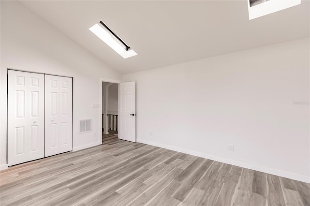 21048 Peachland Blvd, Port Charlotte, FL 33954 - unfurnished bedroom with a skylight, light wood-style flooring, vaulted ceiling, baseboards, and a closet