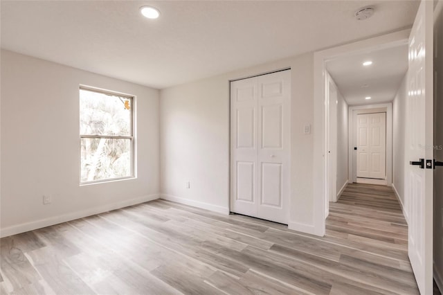 unfurnished bedroom featuring a closet and light hardwood / wood-style floors