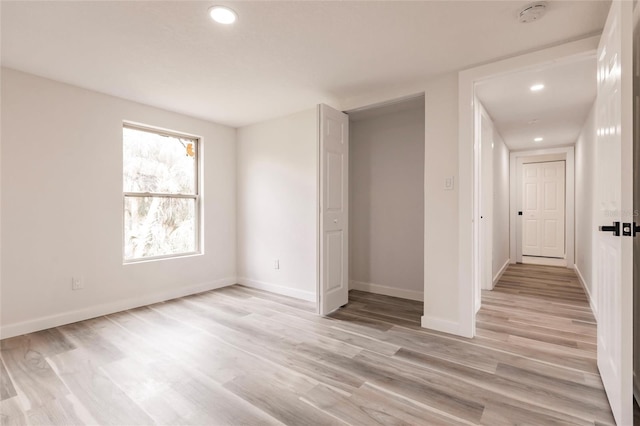 unfurnished bedroom with light wood-type flooring and a closet