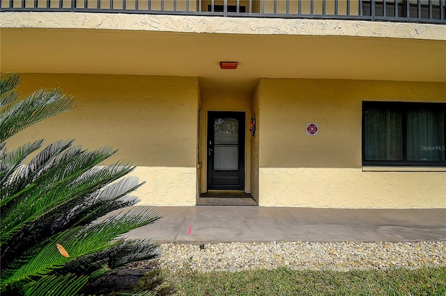 view of exterior entry featuring a balcony