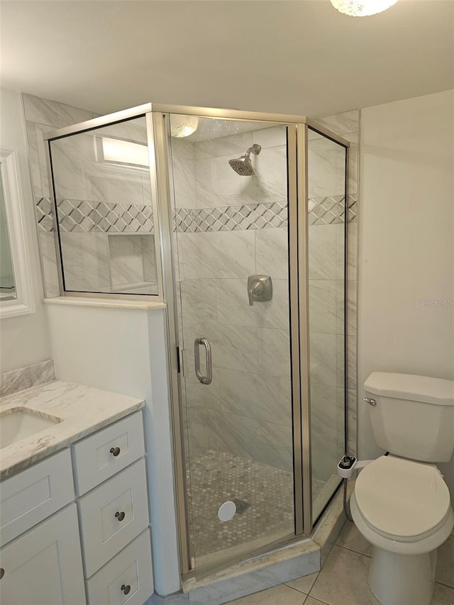 bathroom with toilet, vanity, an enclosed shower, and tile patterned floors