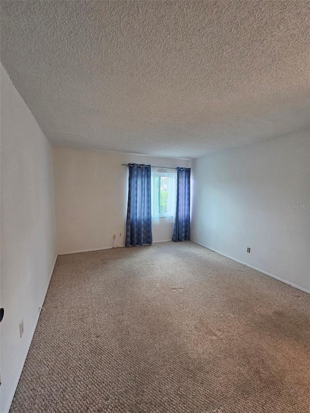 carpeted spare room featuring a textured ceiling