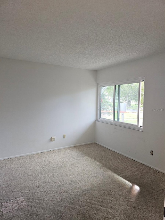 carpeted spare room with a textured ceiling