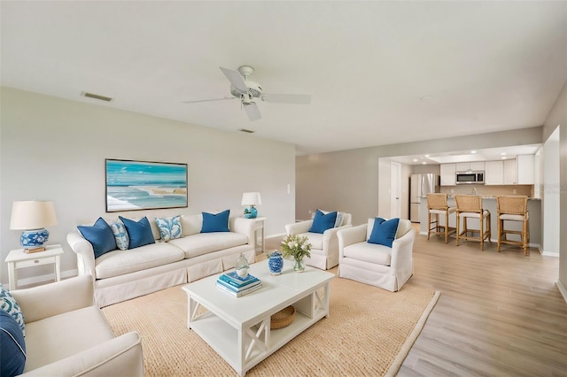 living room featuring ceiling fan and light wood-type flooring