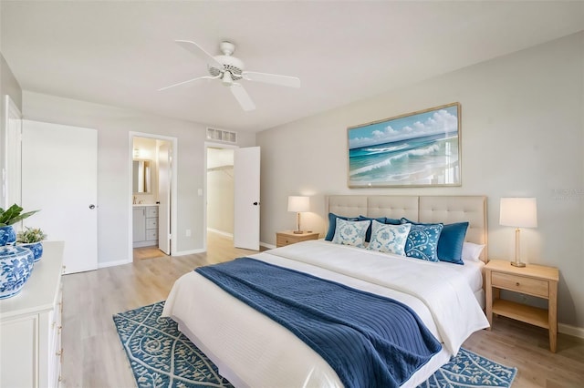 bedroom featuring light wood-type flooring, ensuite bath, and ceiling fan