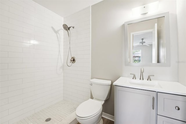 bathroom featuring vanity, ceiling fan, toilet, and tiled shower