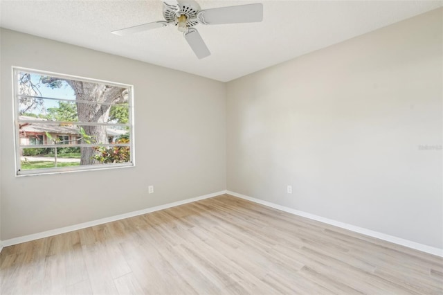 unfurnished room with ceiling fan, a textured ceiling, and light wood-type flooring