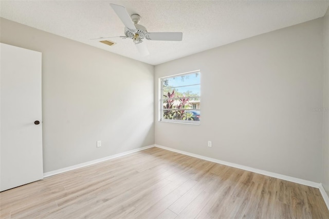 empty room featuring ceiling fan, light hardwood / wood-style flooring, and a textured ceiling