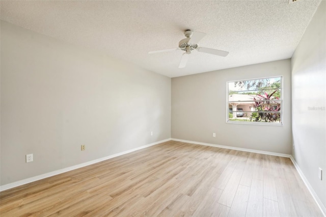 spare room featuring a textured ceiling, light wood-type flooring, and ceiling fan