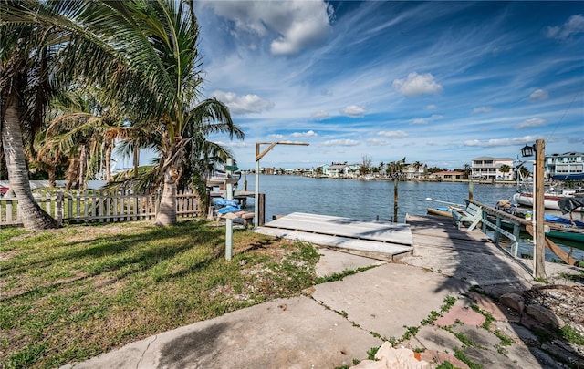 view of dock featuring a water view and a lawn