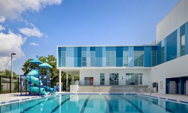 view of swimming pool with a playground and a water slide