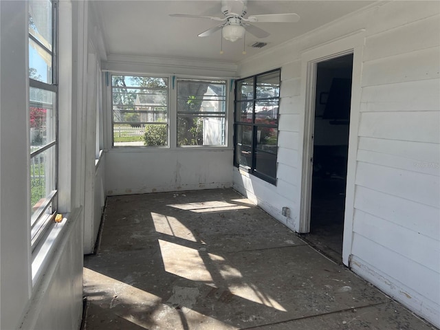 unfurnished sunroom featuring ceiling fan