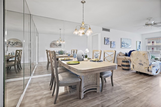 dining room with ceiling fan with notable chandelier and hardwood / wood-style flooring