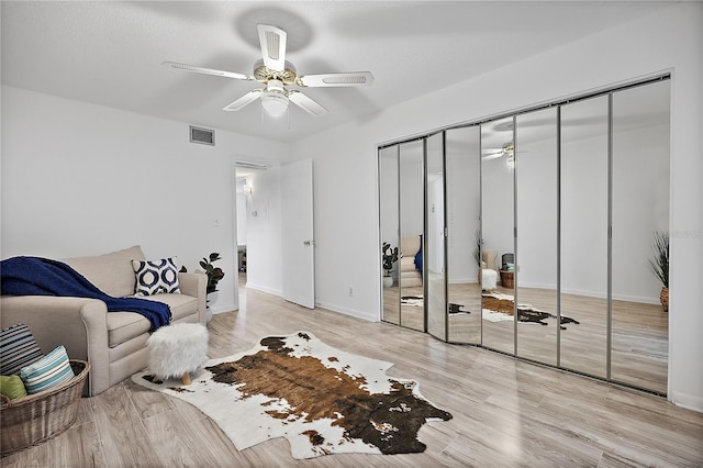 living area with ceiling fan and light hardwood / wood-style floors