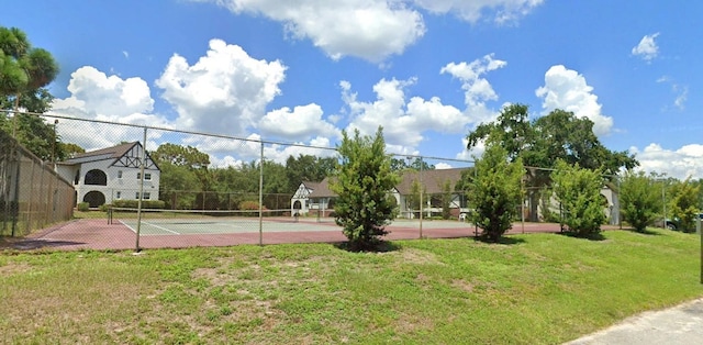 view of tennis court with a lawn