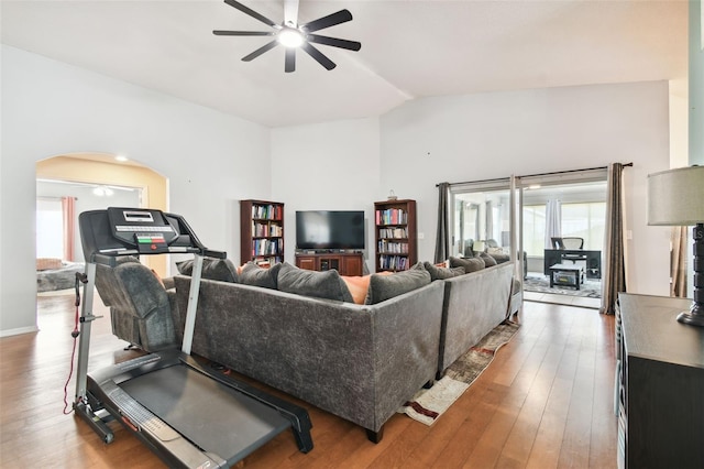 living room with ceiling fan, a healthy amount of sunlight, vaulted ceiling, and hardwood / wood-style flooring