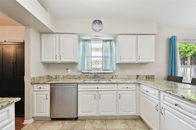 kitchen with white cabinetry, sink, light tile patterned floors, and stainless steel dishwasher